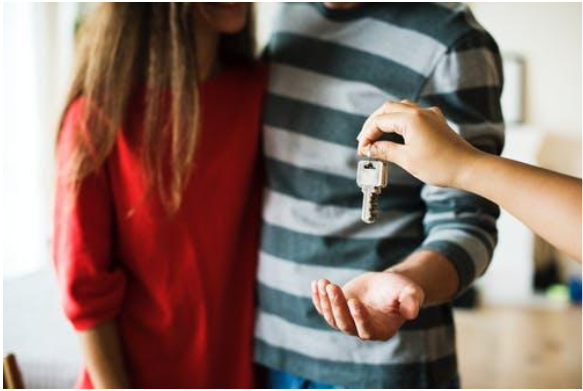 Someone Handing Two People A Key Someone Handing Two People A Key