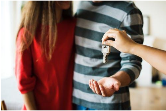 Someone Handing Two People A Key