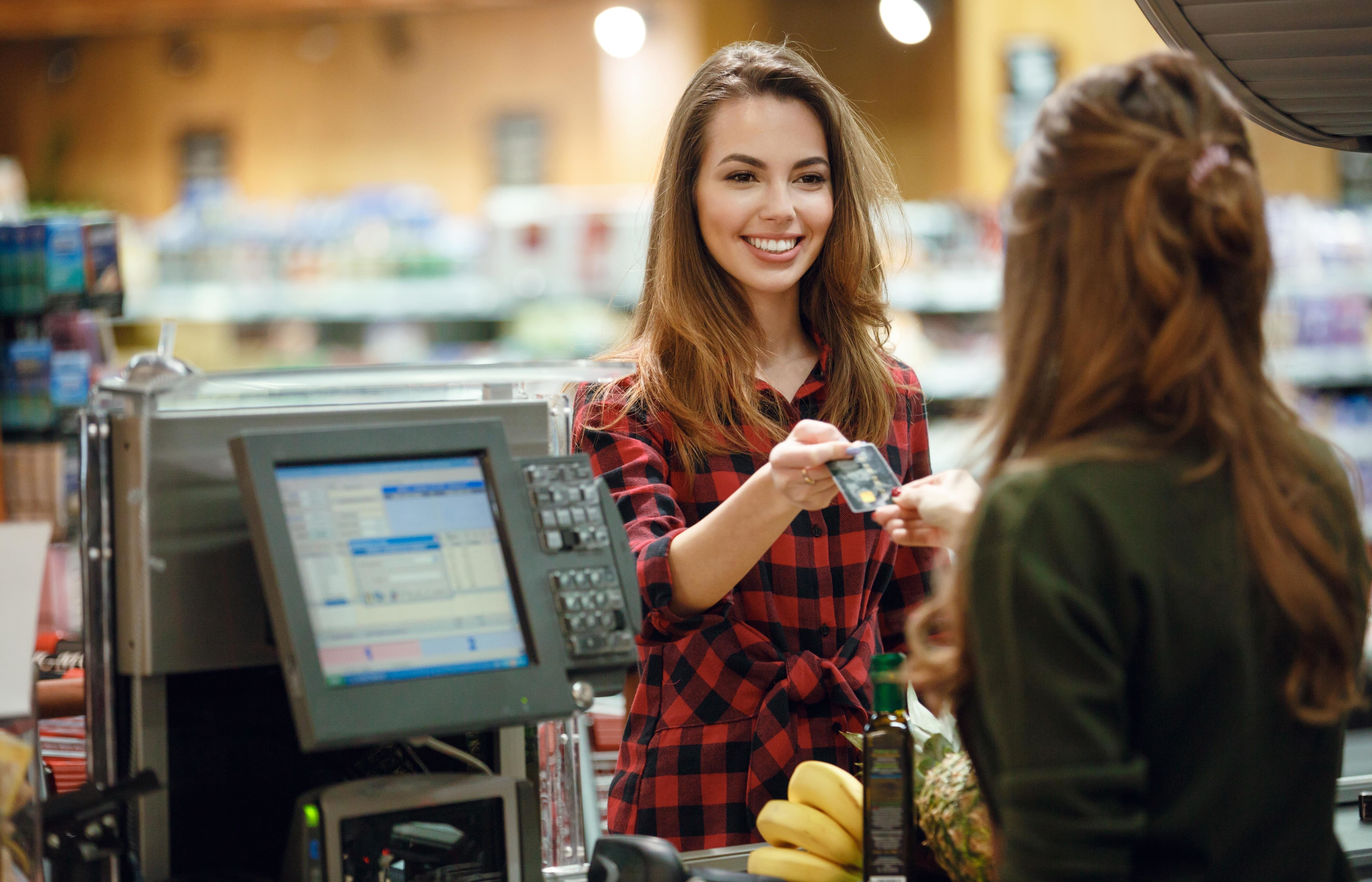 Girl paying the cashier with a store card.