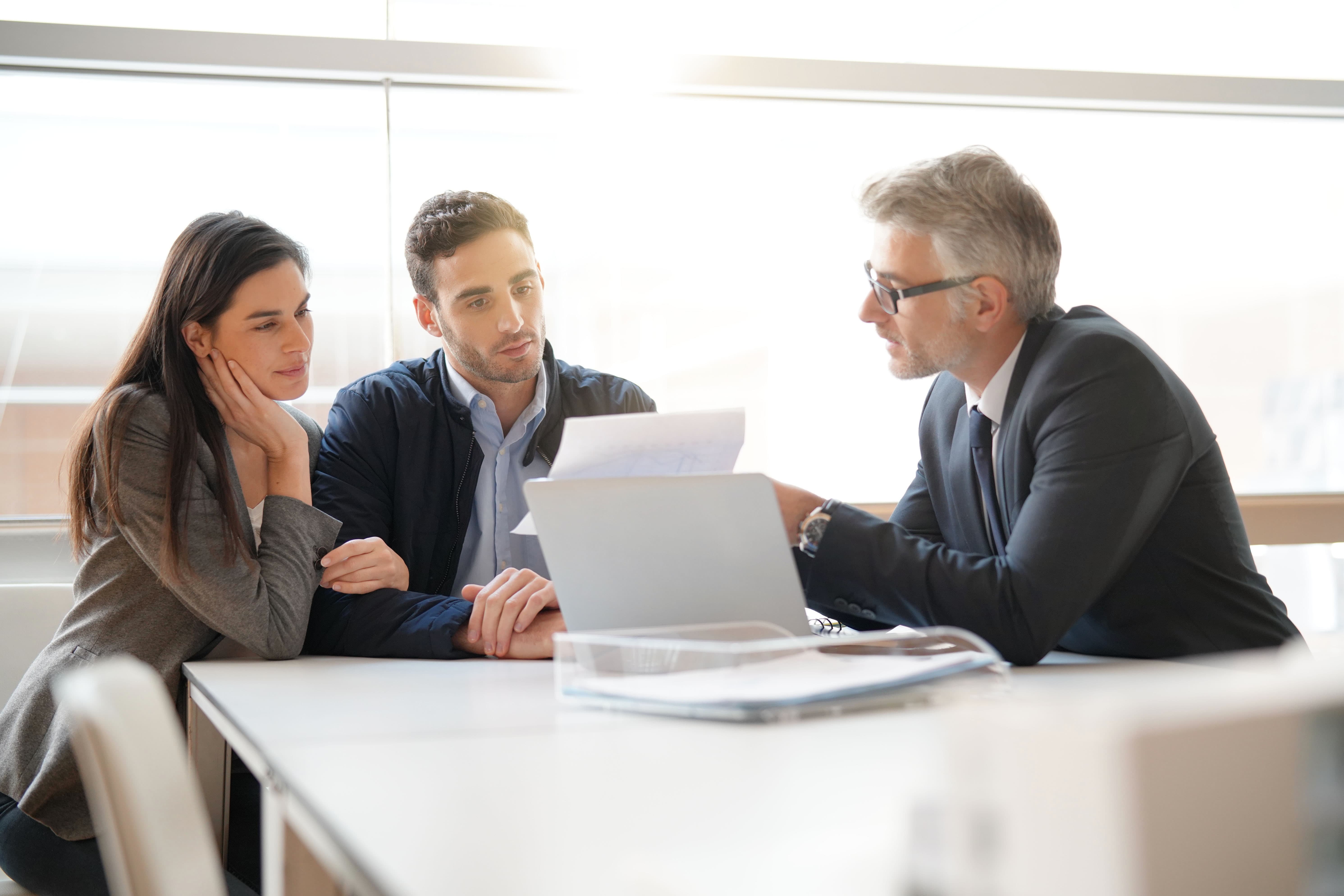 Young couple meeting a banker to get a secured loan.