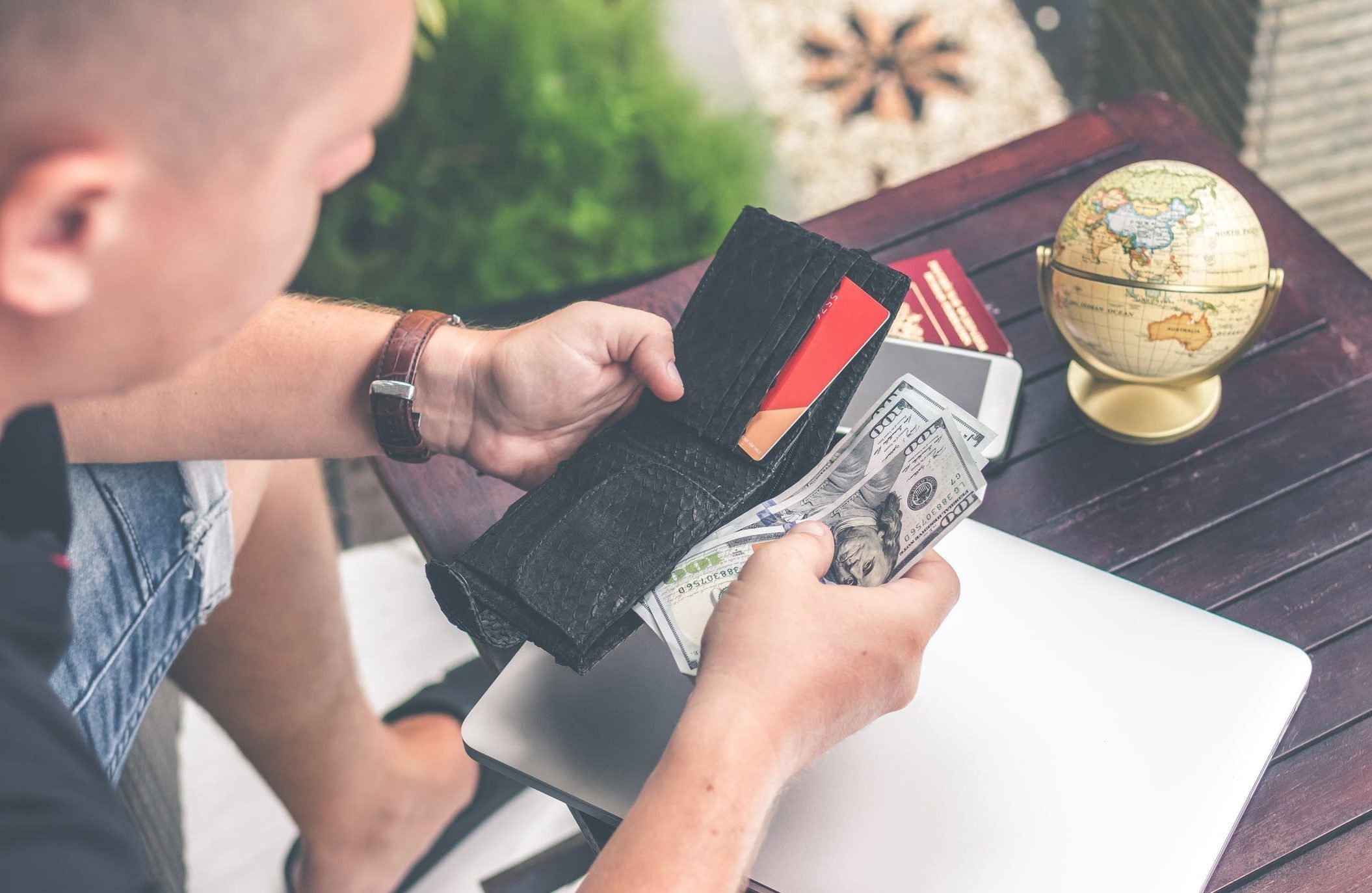 Man holding a purse with cash and credit cards.