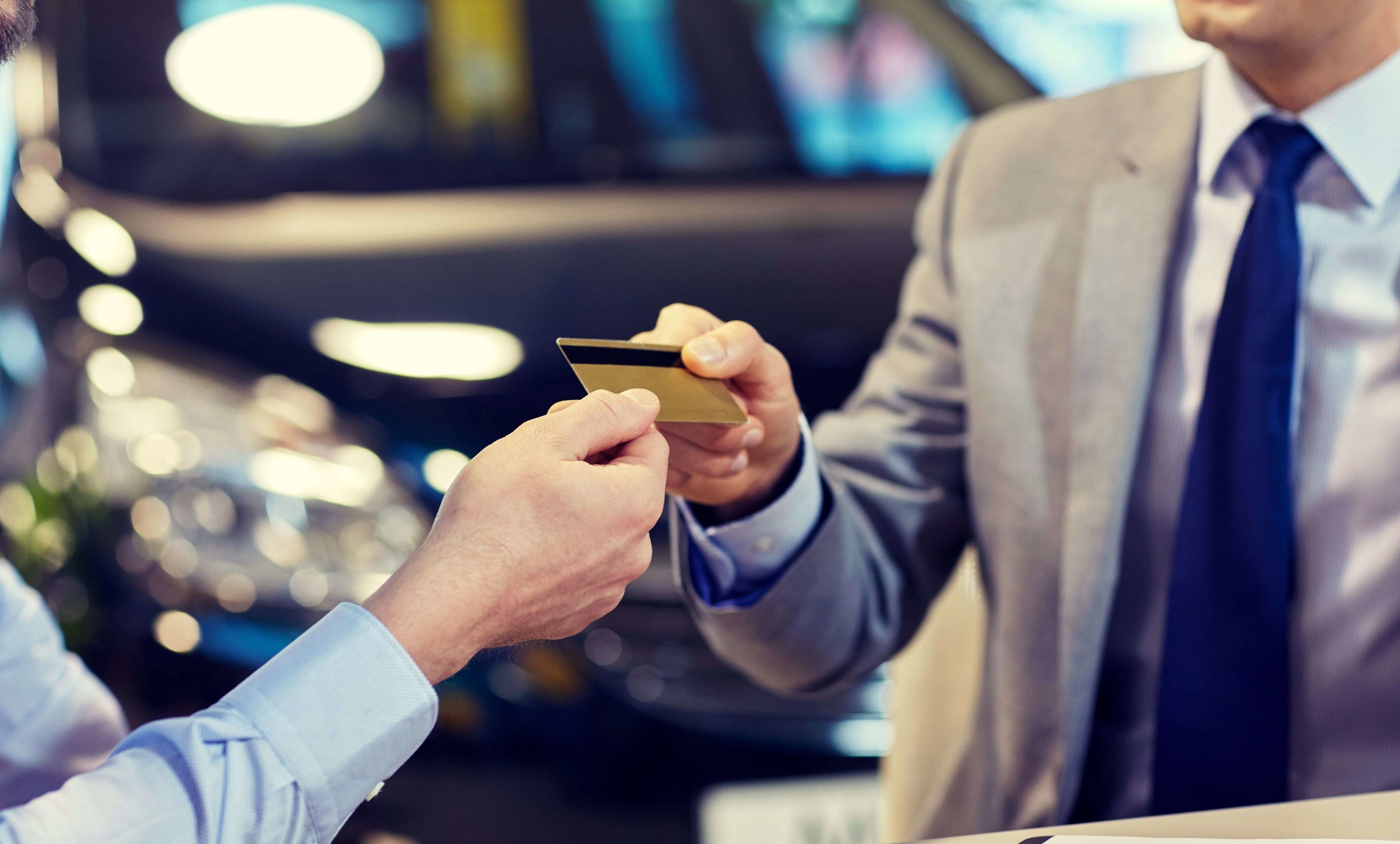 Man handing over a subprime card to another man.