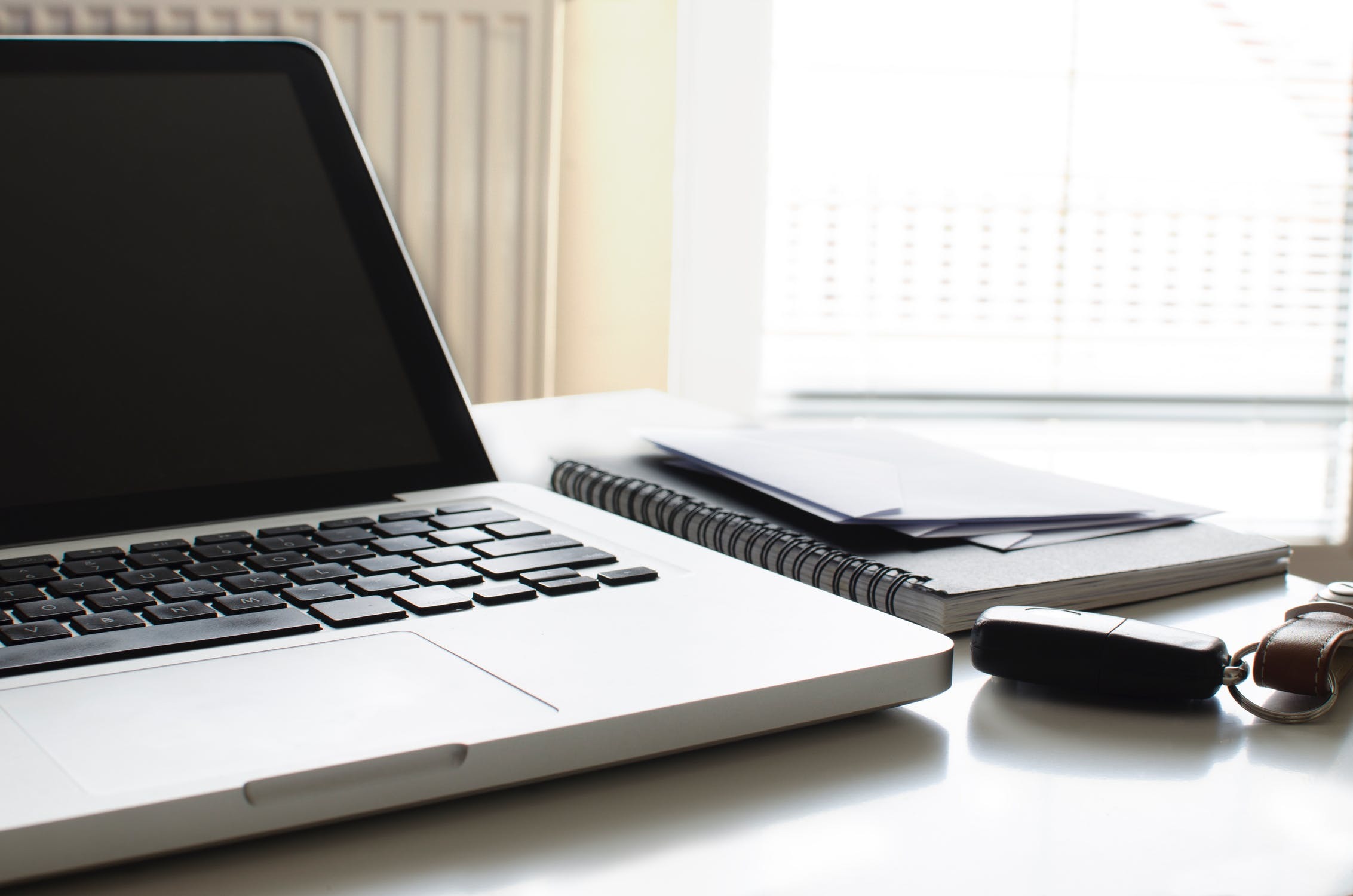 Documents positioned alongside a laptop that contain information about a PLUS score.