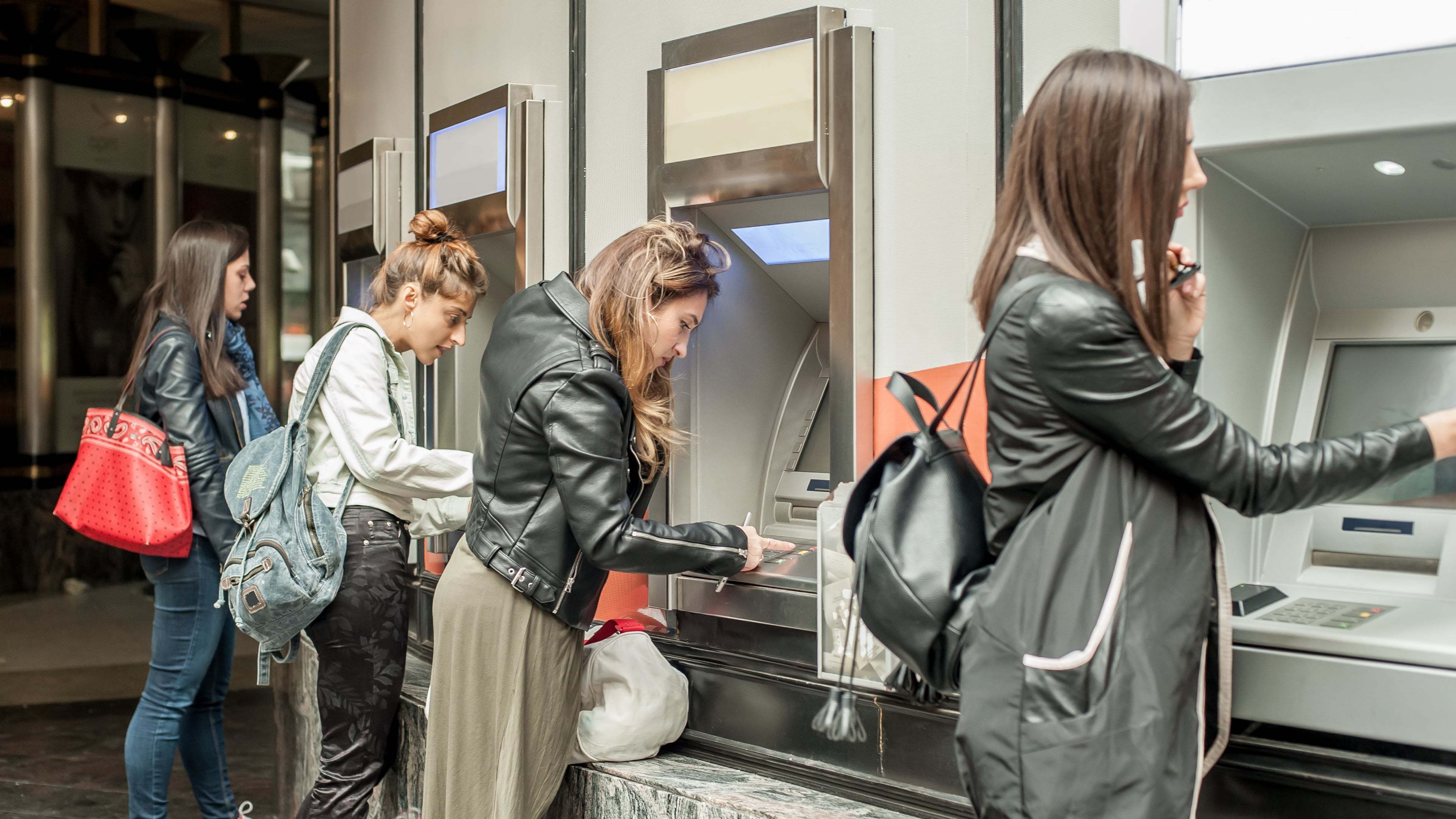 Students using their student credit card to withdraw money from an ATM.